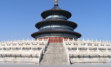 Temple of Heaven, Beijing, Chinatrip, Circular, multi-tiered Chinese temple with blue-green ceramic tiles and gold accents, perched on a stone stairway with a white railing under a clear blue sky.