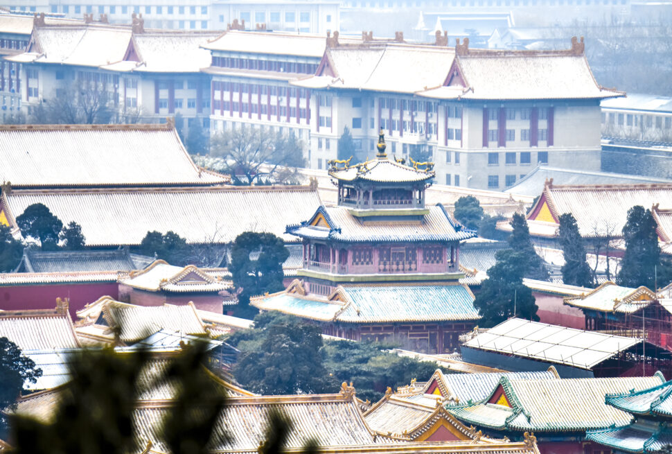 Wide view of a Chinese temple complex with layered, gold-tiled roofs and a central ornate pagoda-like structure in the foreground.