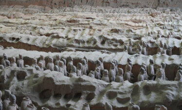 Terra Cotta Warriors, xi'an, china, china tour, Row upon row of life-size terracotta soldiers standing in an ancient excavated pit, part of the Terracotta Army display.