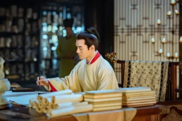 calligraphy, china, china tour, A scholar in traditional robes sits at a wooden desk, writing with a brush among stacked scrolls in a dimly lit, ornate room.