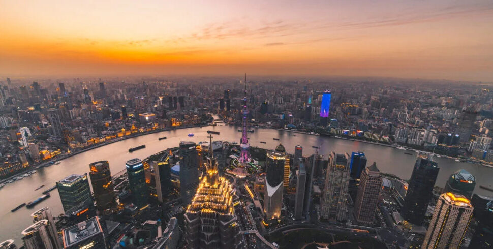 Shanghai's Lujiazui skyline, china, china tour, Aerial view of Shanghai's Lujiazui skyline at sunset, with the Huangpu River winding through illuminated skyscrapers.
