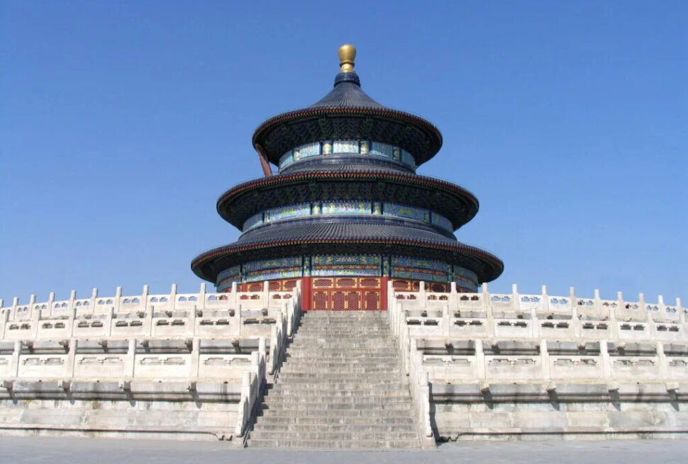 the temple of heaven, beijing, china tour, Three-tiered circular temple with blue-tiled roofs atop a white stone terrace, reached by a long stairway, under a clear blue sky (Temple of Heaven, Beijing)