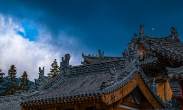 Mount Wutai, shanxi, china, china tour, Ornate Asian temple roof with carved dragons and decorative tiles, blue sky in background.