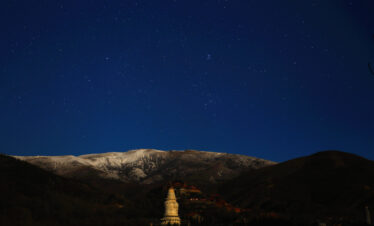 Mount Wutai, shanxi, china, china tour, Night sky filled with stars over snow-dusted mountains and a lit Buddhist stupa in the foreground