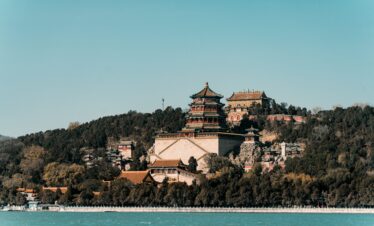 Summer Palace, beijing, china, chinatrip, Traditional Chinese pagoda on a hill overlooking a blue lake, surrounded by trees and smaller buildings in the foreground
