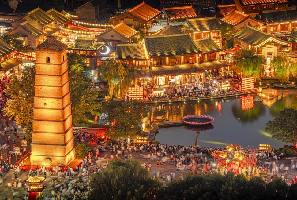 luoyi ancient city, luoyang, henan, china tour, Night view of a lantern-lit traditional Chinese town at night with pagoda roofs and a crowded riverside scene by the water.
