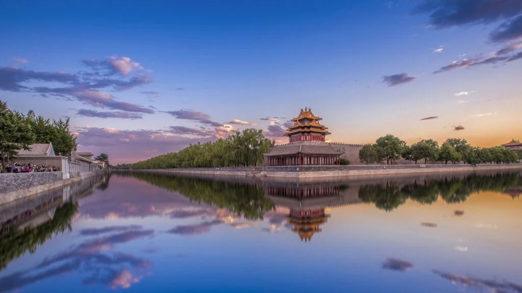 forbidden city, beijing, chinatrave, Traditional Chinese pagoda by a lake at sunset, reflected in the calm water.