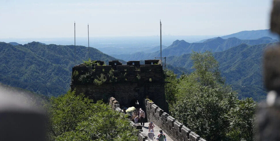 The great wall, beijing, chinatravel, Section of the Great Wall on a hillside, with visitors walking along the stone battlements and surrounding green mountains.