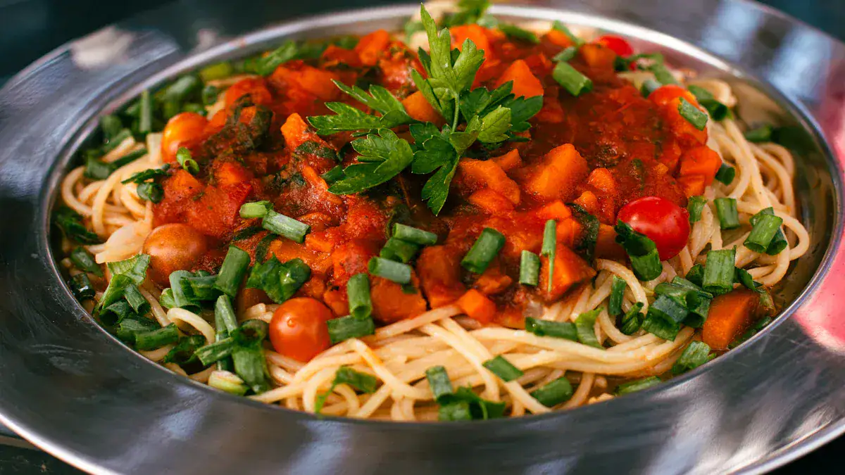 Spaghetti topped with tomato sauce and chopped greens in a metal bowl, garnished with parsley and green onions.