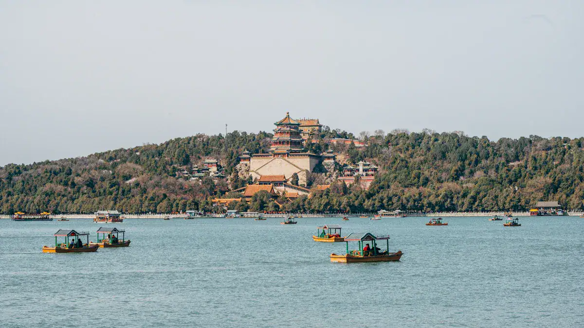 Summer Palace,Beijing,Chinatour Lake with small colorful boats in the foreground and a forested hill topped by a traditional multi-tier pagoda and temple complex in the distance to the right of center.