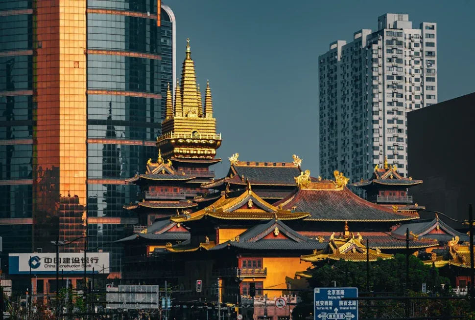 Jing'an Temple,Shanghai,Chinatour Golden-roofed Chinese temple complex in front of modern glass skyscrapers in a city street.