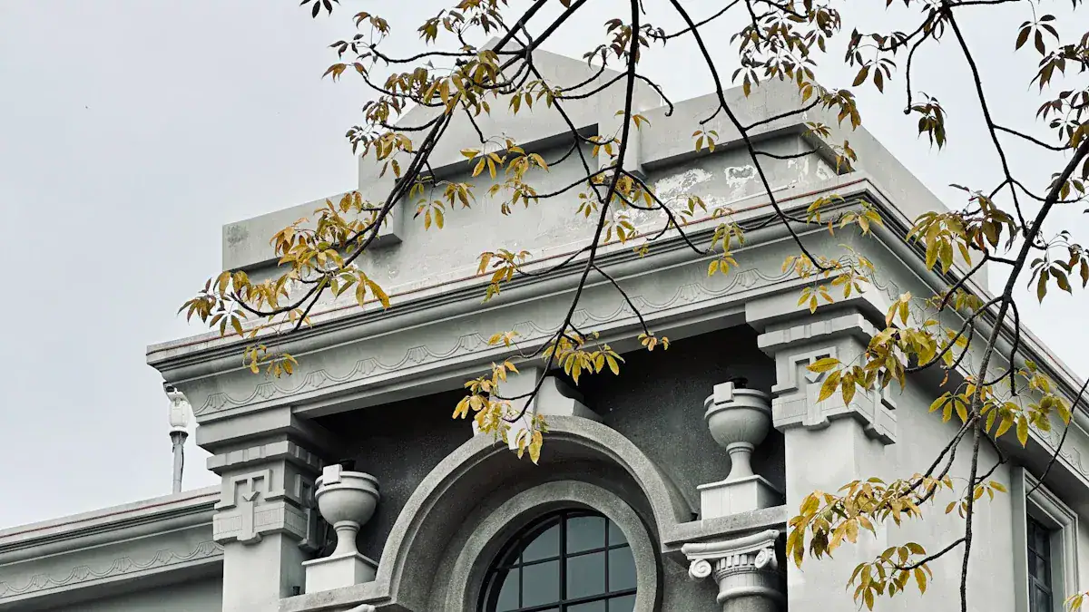 Shanghai's French Concession,Shanghai,Chinatour Stone building facade with an arched window and decorative columns, tree branches with yellowing leaves in the foreground.