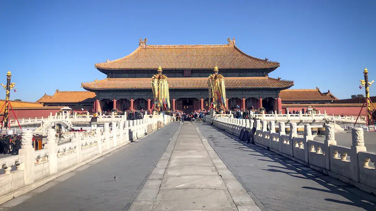 The Palace of Heavenly Purity,Beijing,Chinatour Wide stone walkway leads to a grand traditional Chinese imperial hall with yellow-tiled roof and red columns, surrounded by visitors at a historic palace complex.