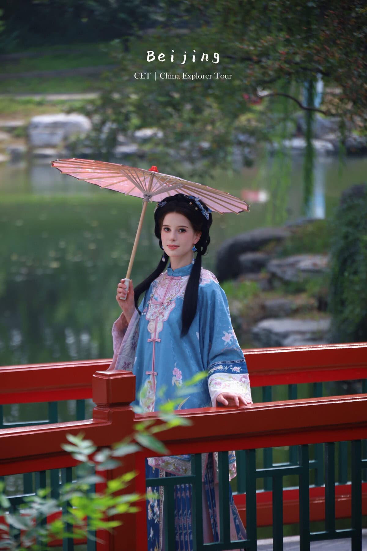 hanfu photoshoot, the forbidden city, beijing, qing dynasty, female, solo, chinatravel, Woman in a blue traditional Chinese dress holding a pink parasol on a red railing beside a tranquil pond in a Chinese garden they likely beijing tourism context