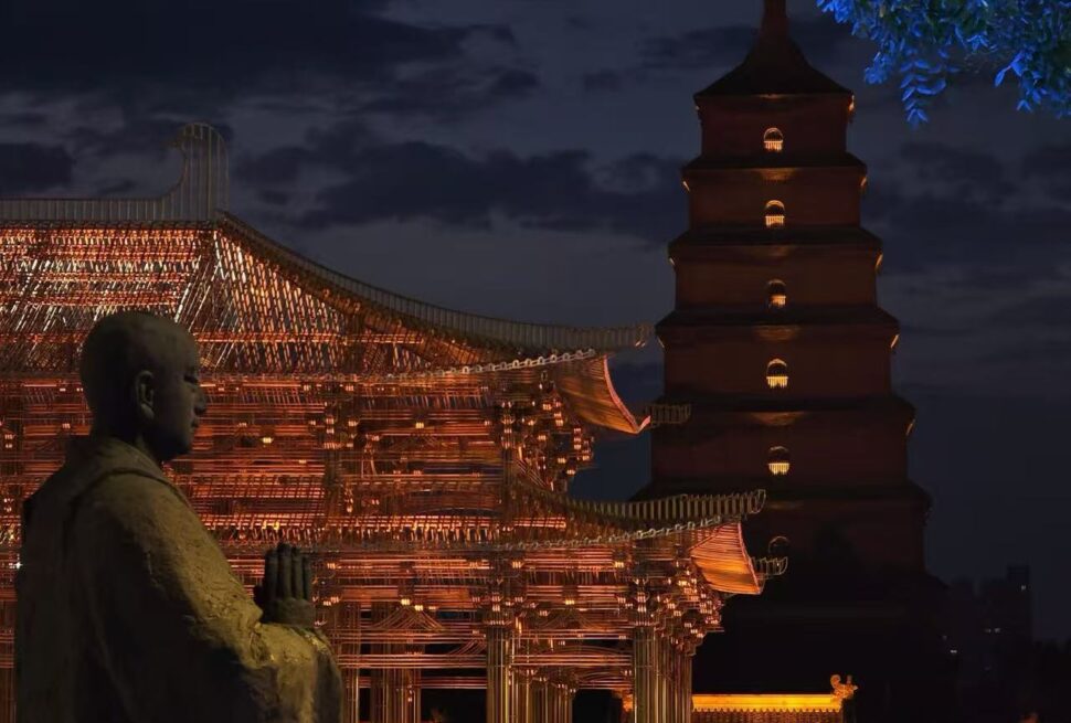 Wild Goose Pagoda and North Square,Xi`an,Chinatour Night scene of a lit Chinese temple pavilion with a tall pagoda and a stone statue in the foreground at night.