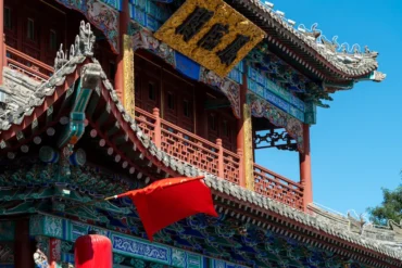 Wuhou Shrine,Chengdu,Chinatour Traditional Chinese temple roof with ornate blue, green, and gold detailing and red columns under a clear blue sky