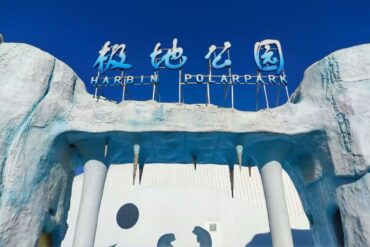 Harbin Polarland,Harbin,Chinatour Entrance to Harbin Polar Park with an icy blue arch and a blue sign reading 'Harbin Polar Park' against a clear sky.
