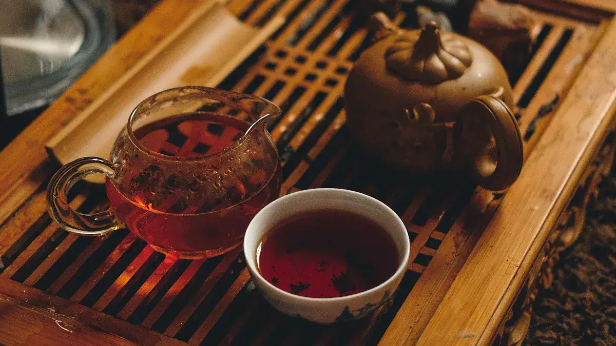 Chengdu's Best Tea House,Chengdu,Chinatour Glass teapot with red tea, white cup, and a brown ceramic teapot on a wooden tray.