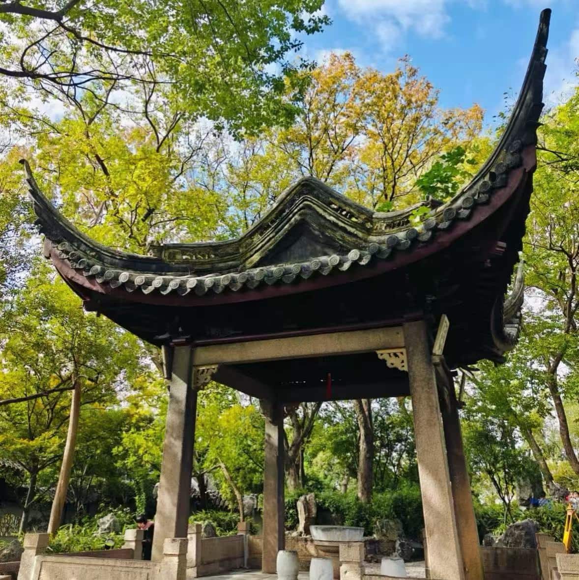 Canglang Pavilion,Suzhou,Chinatour Traditional Chinese pavilion with curved tiled roof in a green garden setting under a blue sky