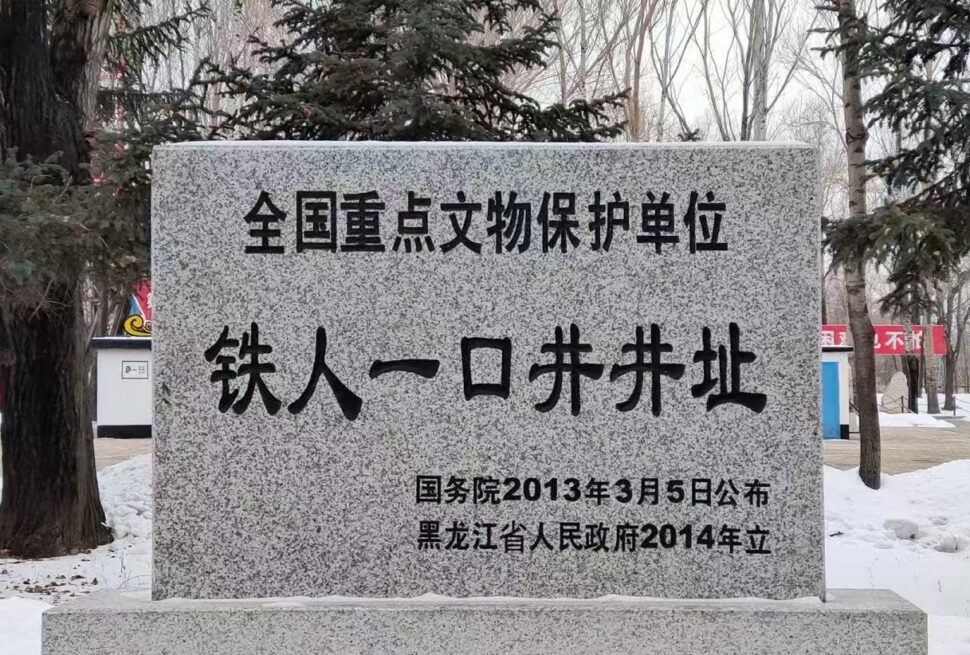 Daqing Oil Well No.1 Site,Daqing,Chinatour Granite stele with Chinese inscription declaring a national key cultural relic protection site, set in a snowy park with trees in the background.