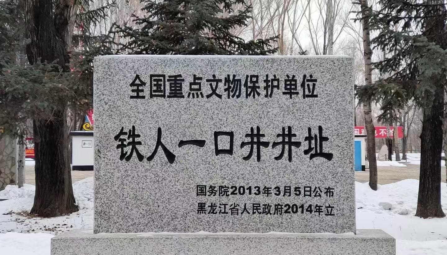 Daqing Oil Well No.1 Site,Daqing,Chinatour Granite stele with Chinese inscription declaring a national key cultural relic protection site, set in a snowy park with trees in the background.