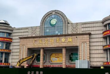 Fangcun Tea Market,Guangzhou,Chinatour Front view of Guangdong Fangcun Tea Industry City building in China, with construction machinery visible near the entrance.