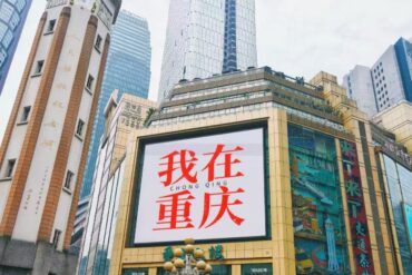 Jiefangbei Pedestrian Street,Chongqing,Chinatour Large billboard on a gold-framed building in Chongqing displaying red Chinese text '我在重庆' (I'm in Chongqing).