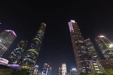 Zhujiang New Town CBD,Guangzhou,Chinatour Nighttime city skyline with tall, illuminated skyscrapers against a dark sky, colorful building lights creating a vibrant urban vista