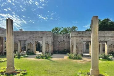 Qingjing Mosque,Quanzhou,Chinatour Stone-clad courtyard with arches and tall columns, green lawn, and a bright blue sky behind the historic structure.