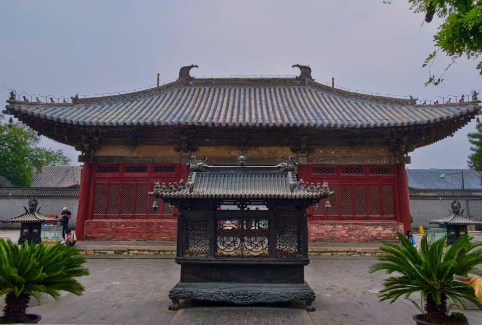 Dule Temple,Tianjin,Chinatour Traditional Chinese temple gate with a gray tiled roof and red wooden walls in a courtyard setting.