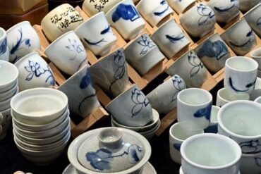 Jingdezhen Intangible Cultural Heritage Market,Jingdezhen,Chinatour Stacks and rows of white ceramic bowls and cups with blue floral designs for sale or display.