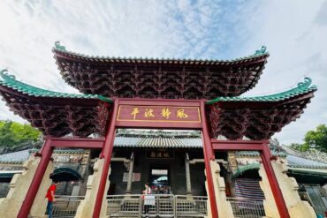 Ornate Chinese temple gate with sweeping green-tiled roofs and a gold plaque; visitors pass through the entrance.Fubo Hill Temple,Guilin,Guangxi ,Chinatravel