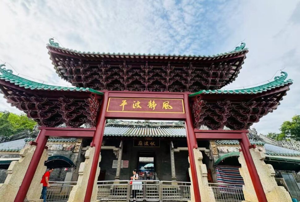 Ornate Chinese temple gate with sweeping green-tiled roofs and a gold plaque; visitors pass through the entrance.Fubo Hill Temple,Guilin,Guangxi ,Chinatravel