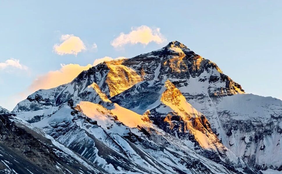 Snow-capped mountain peak bathed in warm sunset light against a clear blue sky.Mount Everest Base Camp,Lhasa,Tibet,Chinatravel