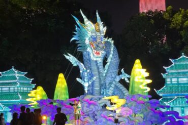 Illuminated blue dragon sculpture at a night festival, surrounded by glowing clouds and pagoda buildings.Orange Isle (Juzizhou) Pavilion,Changsha,Hunan ,Chinatravel
