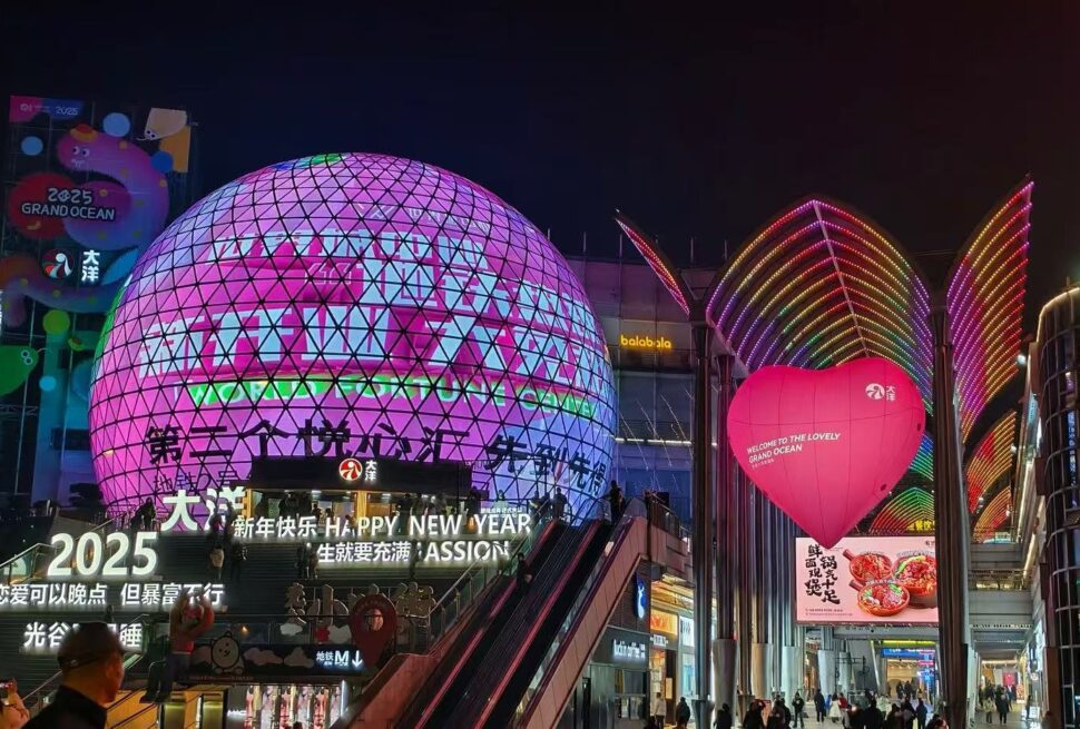 Night view of a neon-lit plaza with a large pink geodesic dome and a pink heart-shaped balloon reading 'Welcome to the Grand Ocean'Optics Valley Shopping Center,Wuhan,Hubei ,Chinatravel