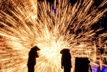 Two silhouettes watch a bright shower of golden sparks against a dark night.Datiehua,𝐂𝐡𝐢𝐧𝐞𝐬𝐞 𝐍𝐞𝐰 𝐘𝐞𝐚𝐫,Henan,Chinatravel