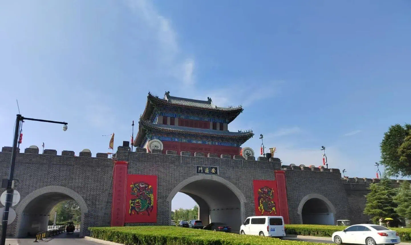 Kaifeng Ancient City Wall,Kaifeng,Henan,Chinatravel Traditional Chinese city gate with a multi-tier pagoda on top, gray brick walls, red banners, and arched entryways.