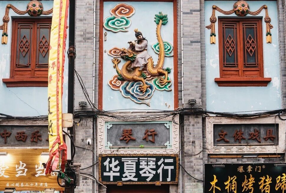 Bookstore Street,Kaifeng,Henan,Chinatravel Facade of a Chinese storefront row with a dragon mural above the entrance, ornate windows, and Chinese signs below.