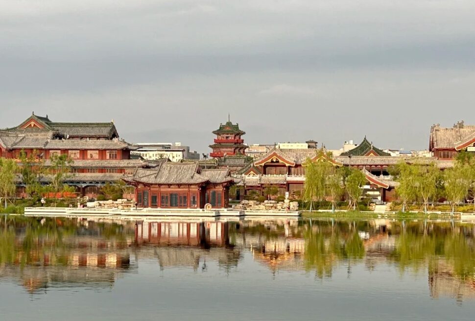 Baogong Lake & Park,Kaifeng,Henan,Chinatravel Traditional Chinese temple complex along a calm lake with reflections in the water and trees lining the shore.