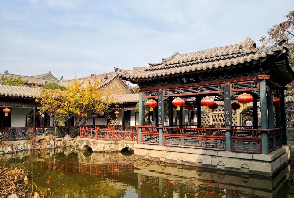 Traditional Chinese pavilion with red lanterns over a pond in a historic garden,Shihu Garden, weifang, shandong, chinatrip