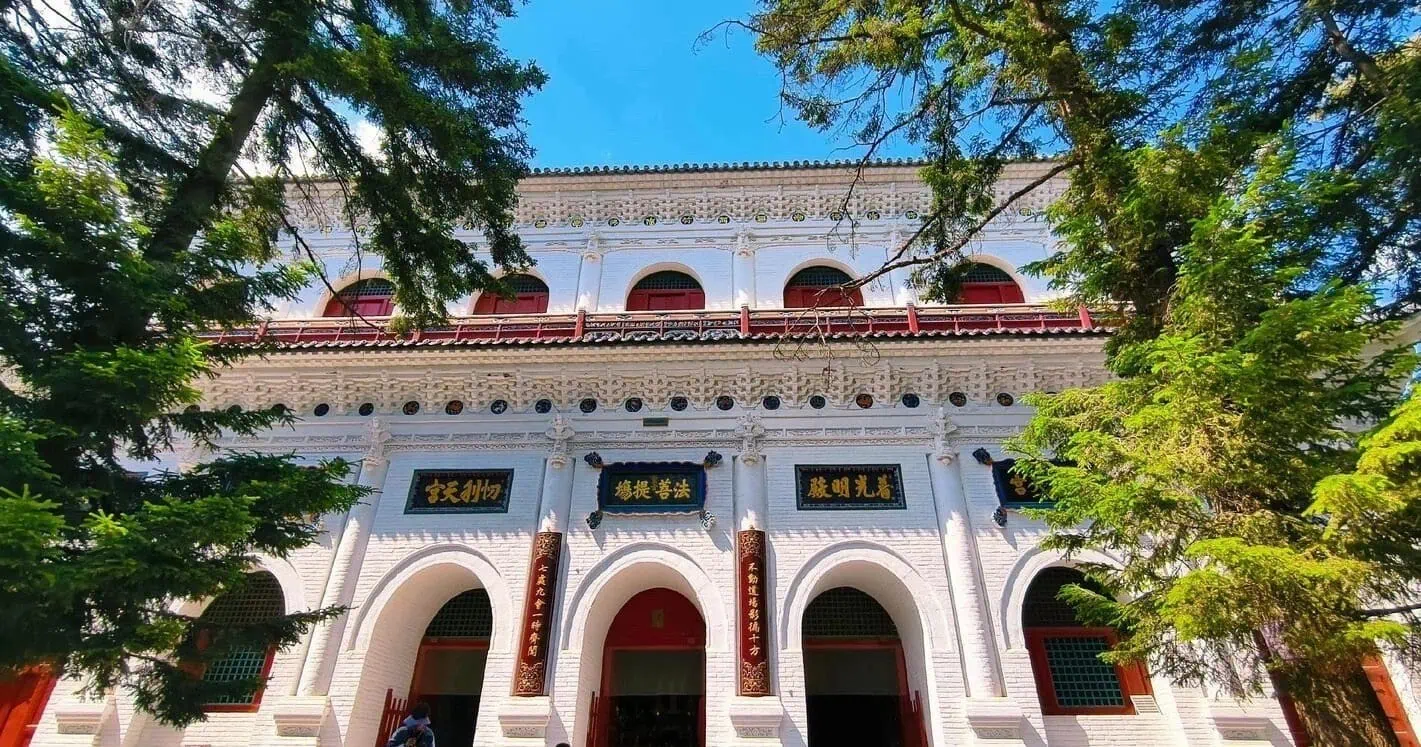 White historic building with traditional Chinese architectural details and red accents.