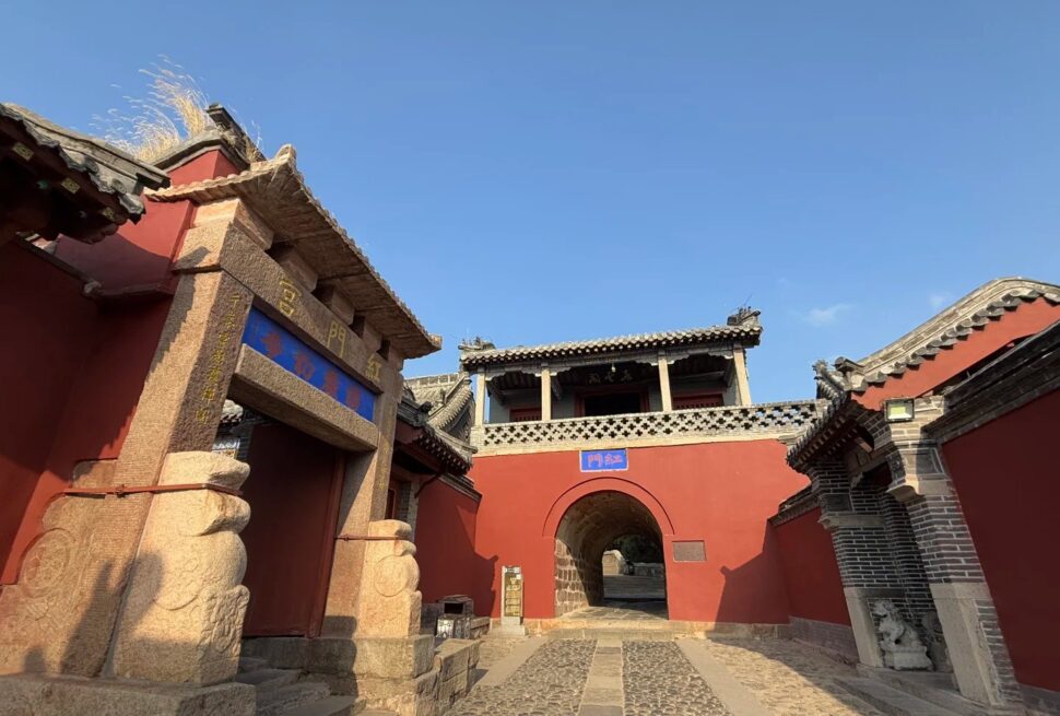 Red Gate Palace Scenic,Tai`an,Chinatour Traditional Chinese architecture with red walls and stone pathway in a historic site.
