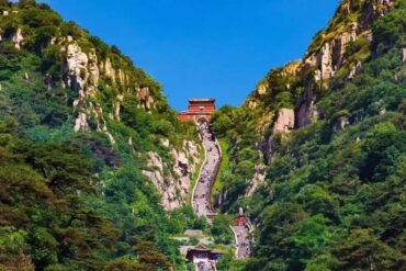 Jade Emperor Peak,Tai`an,Chinatour A scenic view of Mount Hua with a steep pathway and traditional Chinese temple at the top.
