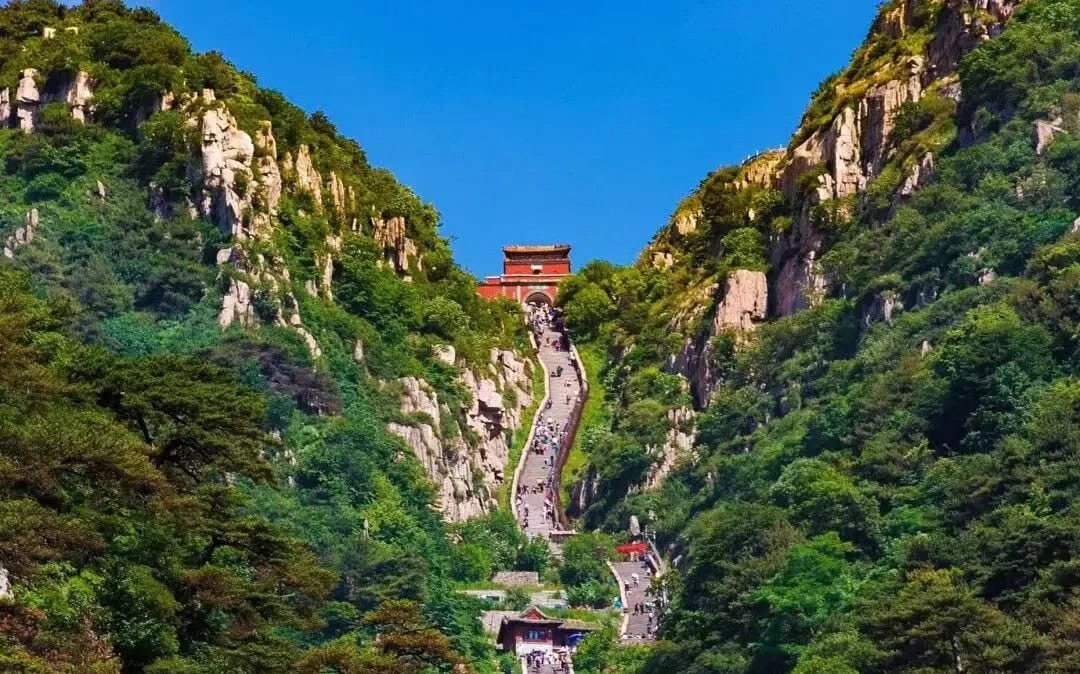 Jade Emperor Peak,Tai`an,Chinatour A scenic view of Mount Hua with a steep pathway and traditional Chinese temple at the top.