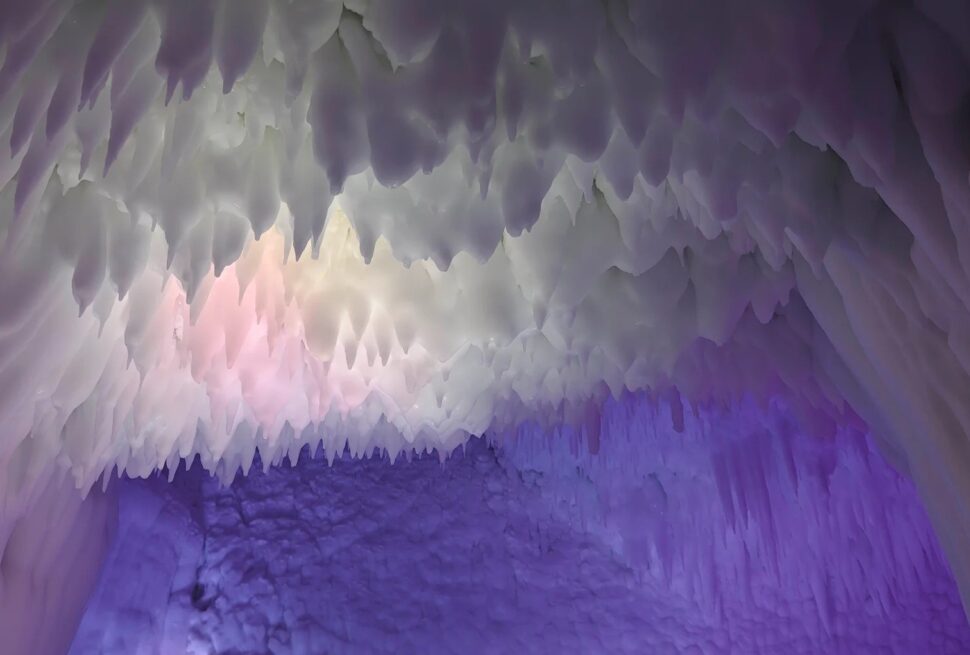 Ice cave ceiling with hanging icicles bathed in purple and blue light, creating a cool, otherworldly glow on the icy walls,Yunqiu Mountain Ice Caves,Linfen,Shanxi