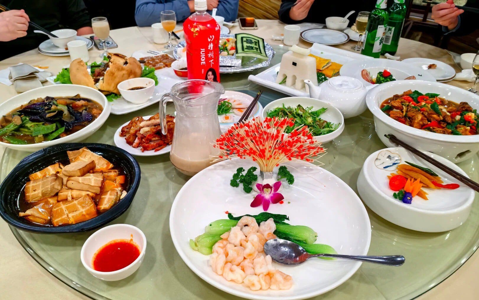 A colorful Chinese banquet with various traditional dishes on a round table.