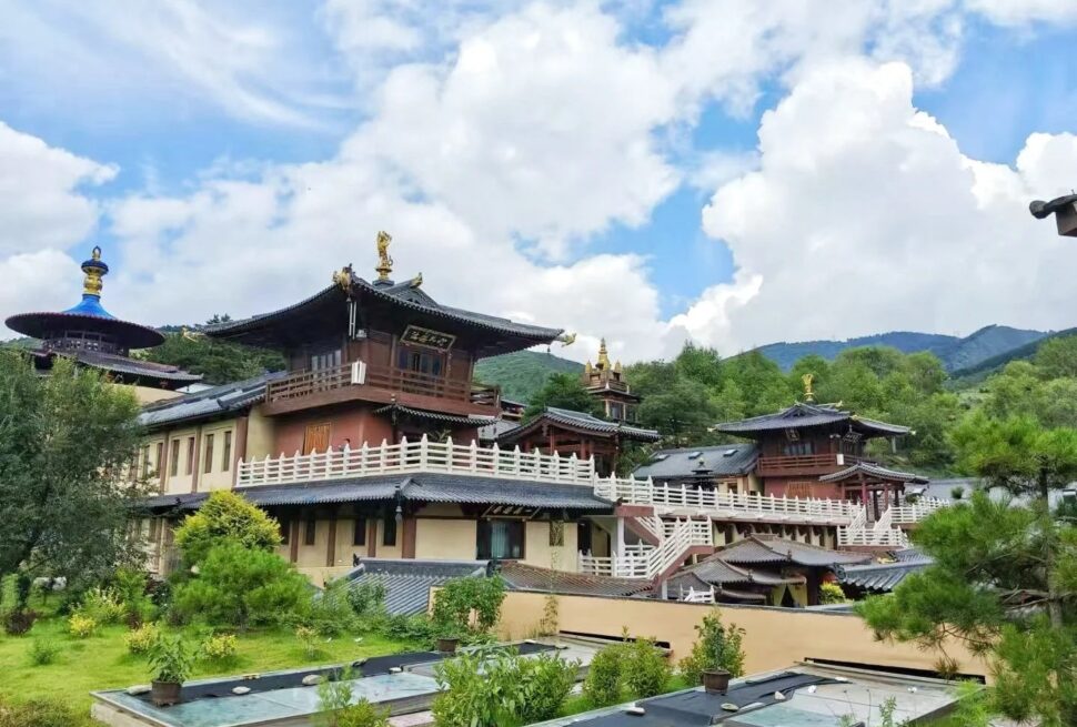Traditional multi-story temple complex with curved roofs and white railings set in green hills under a blue sky,Ancient Manjushri Temple,Xinzhou,Shanxi