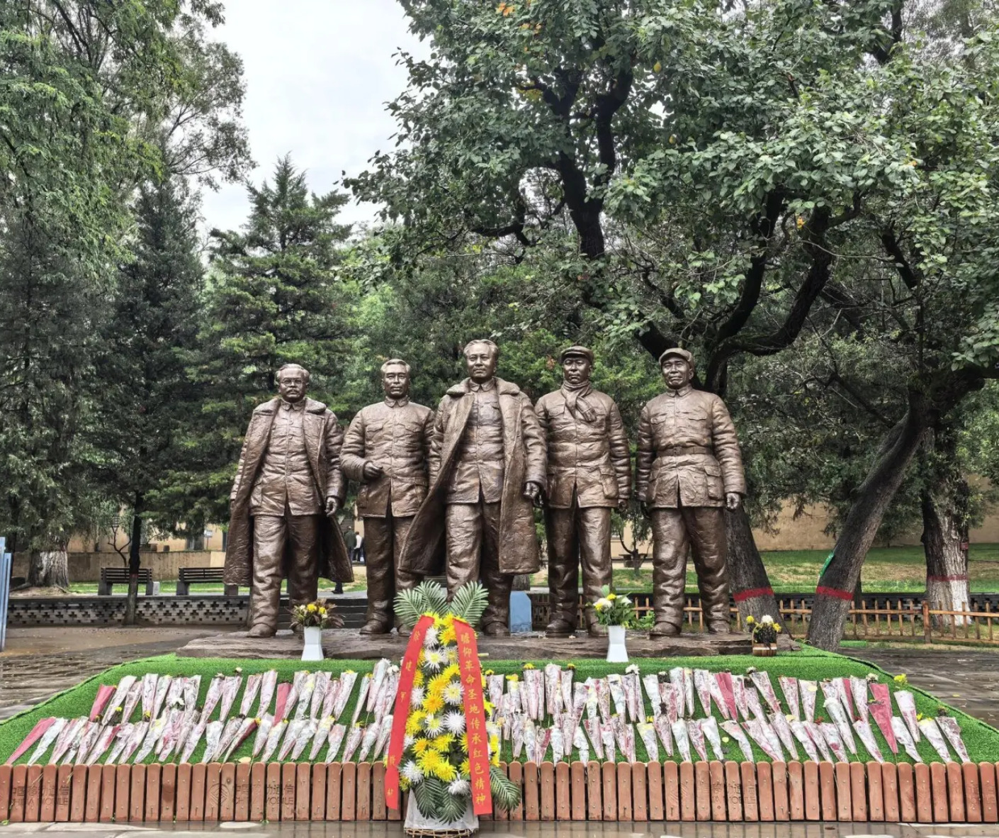 Zaoyuan Revolutionary Former Site ,Yan`an,Chinatrip Bronze statues of five soldiers standing in a park with trees and flowers in front.