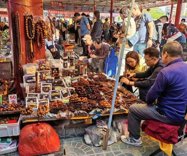 panjiayuan, beijing, chinatravel, Street market stall under colorful umbrellas selling wooden bead bracelets and jewelry, with shoppers browsing nearby.
